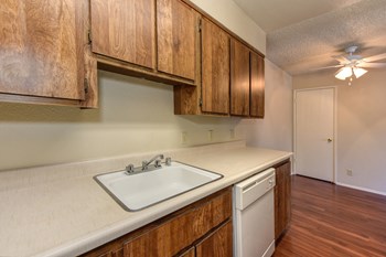 Kitchen with Hardwood Inspired Floors, Oven, Stove, Wood Cabinets and Sink Countertop
